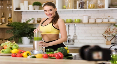 mulher fitness preparando suco de frutas detox pós treino.